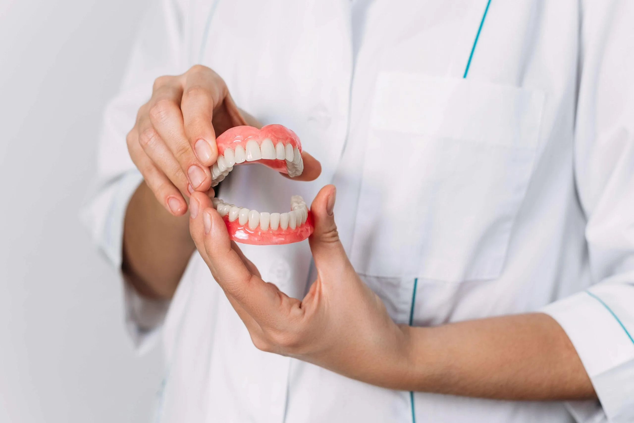 假牙膺復 1 the dentist is holding dentures in his hands scaled